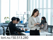 Portrait of an Asian female rookie in the new entrepreneurial team in the business of investment services. Стоковое фото, агентство Ingram Publishing / Фотобанк Лори