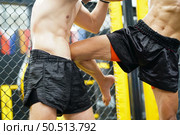 Mixed Martial Art, The power of a knee into the opponent’s abdomen causing the opponent to have colic, tightness in the stomach and lose by knockout. Стоковое фото, агентство Ingram Publishing / Фотобанк Лори
