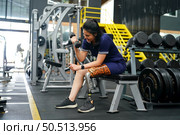 Young female with one prosthetic leg warms up by lifting light weights. Concept of living a woman’s life with a prosthetic limb. Стоковое фото, агентство Ingram Publishing / Фотобанк Лори