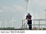 Engineer at Natural Energy Wind Turbine site with a mission to climb up to the wind turbine blades to inspect the operation of large wind turbines that converts wind energy into electrical energy. Стоковое фото, агентство Ingram Publishing / Фотобанк Лори
