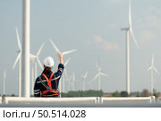 Engineer at Natural Energy Wind Turbine site with a mission to climb up to the wind turbine blades to inspect the operation of large wind turbines that converts wind energy into electrical energy. Стоковое фото, агентство Ingram Publishing / Фотобанк Лори