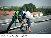 Engineer in charge of solar panel installation The installation of solar energy conversion into electricity for a warehouse is currently being investigated. Стоковое фото, агентство Ingram Publishing / Фотобанк Лори