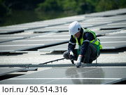 Engineer in charge of solar panel installation The installation of solar energy conversion into electricity for a warehouse is currently being investigated. Стоковое фото, агентство Ingram Publishing / Фотобанк Лори