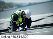 Engineer in charge of solar panel installation The installation of solar energy conversion into electricity for a warehouse is currently being investigated. Стоковое фото, агентство Ingram Publishing / Фотобанк Лори