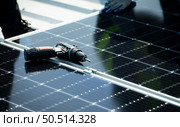 Both of Engineer in charge of solar panel installation The installation of solar energy conversion into electricity for a warehouse is currently being investigated. Стоковое фото, агентство Ingram Publishing / Фотобанк Лори