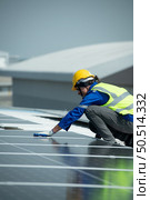 Engineer in charge of solar panel installation The installation of solar energy conversion into electricity for a warehouse is currently being investigated. Стоковое фото, агентство Ingram Publishing / Фотобанк Лори