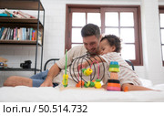 Father with little girl have fun playing with your new toys in the bedroom together. Toys that enhance children’s thinking skills. Стоковое фото, агентство Ingram Publishing / Фотобанк Лори