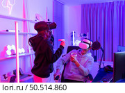 Two professional gamer playing games through VR machine that responds to very fun exciting and provocative. Стоковое фото, агентство Ingram Publishing / Фотобанк Лори