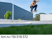 Skateboarder doing ollie trick on a urban scene. Стоковое фото, агентство Ingram Publishing / Фотобанк Лори