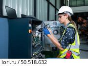 Female Technician Inspecting and repairing robotics arm in robots hangar and test the operation of the machine after being used for a while, as well as updating the software and calibration. Стоковое фото, агентство Ingram Publishing / Фотобанк Лори