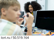 Youngsters utilizing the hand robot technology are having fun learning the electronic circuit board and hand robot controller of robot technology, which is one of the STEM courses. Стоковое фото, агентство Ingram Publishing / Фотобанк Лори