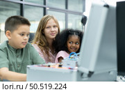 Youngsters utilizing the hand robot technology are having fun learning the electronic circuit board and hand robot controller of robot technology, which is one of the STEM courses. Стоковое фото, агентство Ingram Publishing / Фотобанк Лори