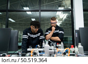 The robotic hand technology teacher is instructing new students on how to use electronic circuit boards and robotic hand commands for a variety of industrial applications. Стоковое фото, агентство Ingram Publishing / Фотобанк Лори
