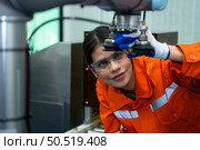 In an electronic parts facility, Female engineers In the plant, inspecting and testing robotic hands used in the production of electronic components. Стоковое фото, агентство Ingram Publishing / Фотобанк Лори