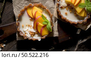 Peach vegan tarts with grated coconut  and crunchy peanuts. Fruit cake. Date, walnut, almond and hazelnut base. Стоковое фото, агентство Ingram Publishing / Фотобанк Лори