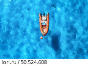 Aerial view of beautiful orange boat in blue sea at sunset in summer. Sardinia, Italy. Top drone view of motorboat, ocean with transparent azure water. Travel. Tropical landscape. Yachting. Seascape. Стоковое фото, агентство Ingram Publishing / Фотобанк Лори