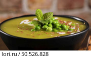 Green pea soup with linseed and pumpkin and sunflower seeds on a rustic kitchen countertop. Стоковое фото, агентство Ingram Publishing / Фотобанк Лори