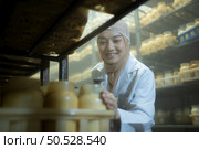 Young asian muslim female scientist doing research at a mushroom factory, examining mushroom leavening agent in a sterile and temperature-controlled room. Стоковое фото, агентство Ingram Publishing / Фотобанк Лори