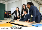 Diverse team of businessmen and engineers consultation on the engineering of a wind turbine that converts wind energy to electricity in the office. Стоковое фото, агентство Ingram Publishing / Фотобанк Лори