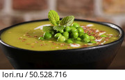 Green pea soup with linseed and pumpkin and sunflower seeds on a rustic kitchen countertop. Стоковое фото, агентство Ingram Publishing / Фотобанк Лори