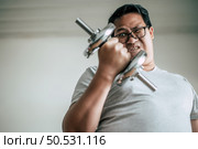 Funny Fat man in glasses lifting up dumbbell to exercise for healthy, copy space. Стоковое фото, агентство Ingram Publishing / Фотобанк Лори
