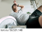 Funny overweight man in glasses closed his eyes and lying exhausted down on the floor after workout, copy space. Стоковое фото, агентство Ingram Publishing / Фотобанк Лори