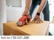 Close up hand of man use glue tape to close cardboard box, sealing big box for packing moving, new house concept, Selective focus	cardboard box, . Стоковое фото, агентство Ingram Publishing / Фотобанк Лори