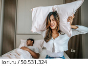 Selective focus Young pretty woman has problem form her husband snoring while sleeping on bed, She use pillow closed ears, blurred man sleep on bed in background, Couple with snoring problem concept. Стоковое фото, агентство Ingram Publishing / Фотобанк Лори