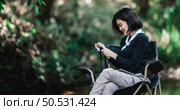 Young pretty woman use digital camera taking a photo beautiful nature while camping in forest with happiness, copy space. Стоковое фото, агентство Ingram Publishing / Фотобанк Лори