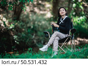 Young pretty woman use digital camera taking a photo beautiful nature while camping in forest with happiness, copy space. Стоковое фото, агентство Ingram Publishing / Фотобанк Лори
