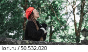 Portrait of Asian young woman in winter costume praying in the morning at the woodland. Christianity and faith hope love concept. Стоковое фото, агентство Ingram Publishing / Фотобанк Лори