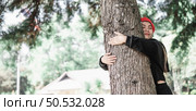 Contented young woman hugging a large tree with a blissful expression with copy space. Concept of care for environment. Стоковое фото, агентство Ingram Publishing / Фотобанк Лори