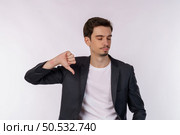 Portrait of young businessman shows sign of dislike, looks with negative expression and disapproval on isolated background. Disagreement, disgust and negative expressions. Стоковое фото, агентство Ingram Publishing / Фотобанк Лори