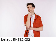 Portrait of young man thinking touching chin isolated over white background. Thinking worried about a question, concerned and nervous with hand on chin. Стоковое фото, агентство Ingram Publishing / Фотобанк Лори