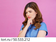 Portrait of young woman wearing casual t-shirt thinking and imagination isolated over pink background. Expression, people and lifestyle concept. Стоковое фото, агентство Ingram Publishing / Фотобанк Лори