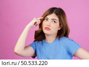 Portrait of young woman wearing casual t-shirt thinking and imagination isolated over pink background. Expression, people and lifestyle concept. Стоковое фото, агентство Ingram Publishing / Фотобанк Лори