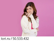 Portrait of Disgusted young woman holding nose to avoid smelling a foul and unpleasant stench against isolated over pink background. Emotion and lifestyle concept. Стоковое фото, агентство Ingram Publishing / Фотобанк Лори