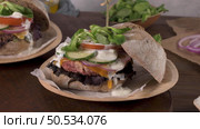 Healthy vegan burger with fresh vegetables and yogurt sauce on rustic kitchen counter top. Стоковое фото, агентство Ingram Publishing / Фотобанк Лори