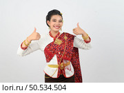 Portrait young pretty woman dress up in beautiful  local culture in northern region with gladtful posture, smile and thumb up on white background, copy space. Стоковое фото, агентство Ingram Publishing / Фотобанк Лори