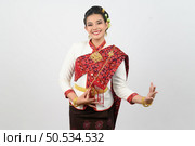 Portrait Young beautiful woman in northeastern dress, she raising hand in Thai dance with charming smile on white background, copy space . Стоковое фото, агентство Ingram Publishing / Фотобанк Лори