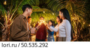Portrait of Happy Asian group of friends having fun with sparklers outdoor - Young people having fun with fireworks at night time  - People, food, drink lifestyle, new year celebration concept. Стоковое фото, агентство Ingram Publishing / Фотобанк Лори