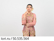 Young beautiful woman dress up in local culture in southern region standing and point finger on her cheek during great idea or thought on white background. Стоковое фото, агентство Ingram Publishing / Фотобанк Лори