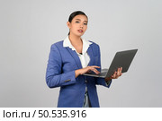 Portrait Asian young woman in officer uniform working on laptop computer posture,  Pretty girl smiling with happy, isolated on white background. Стоковое фото, агентство Ingram Publishing / Фотобанк Лори