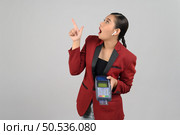 Portrait Asian young woman in officer uniform point finger exciting to showing credit card and payment machine, copy space for insert advertising your product, isolated on white background. Стоковое фото, агентство Ingram Publishing / Фотобанк Лори