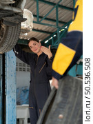 A car mechanic inspects the condition of a car tire before placing it on a vehicle. Стоковое фото, агентство Ingram Publishing / Фотобанк Лори