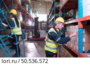 Warehouse foreman and employees Check the imported products in the central warehouse. before delivering to each region’s distribution centers. Стоковое фото, агентство Ingram Publishing / Фотобанк Лори