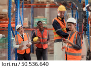Managers, foremen and warehouse workers Consult together about getting the goods out of the warehouse to finish sending the small merchants tonight. Стоковое фото, агентство Ingram Publishing / Фотобанк Лори