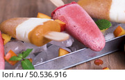 Homemade raspberries and peach popsicles on a wooden table. Стоковое фото, агентство Ingram Publishing / Фотобанк Лори