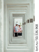 Both of construction engineers verify the constructed precast concrete wall slabs’ quality. also to oversee significant construction projects in the construction zone. Стоковое фото, агентство Ingram Publishing / Фотобанк Лори
