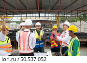 Construction engineers, architects, and foremen form a group. Participate in a meeting to plan new construction projects. Cheers to express happiness that the event was successfully accomplished. Стоковое фото, агентство Ingram Publishing / Фотобанк Лори